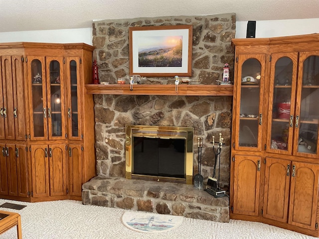 235 Sylvan Dr, Greers Ferry, AR 72067 - carpeted living room with a textured ceiling and a stone fireplace