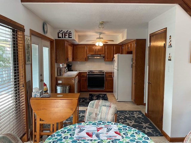 235 Sylvan Dr, Greers Ferry, AR 72067 - kitchen with freestanding refrigerator, range, brown cabinets, under cabinet range hood, and ceiling fan