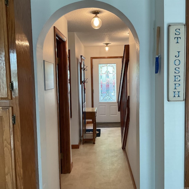235 Sylvan Dr, Greers Ferry, AR 72067 - hall featuring baseboards, a textured ceiling, and arched walkways