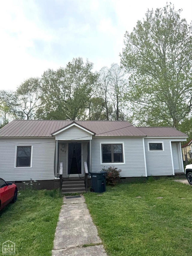 view of front of house featuring a front lawn and metal roof