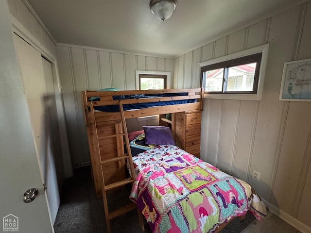 bedroom featuring a decorative wall and baseboards