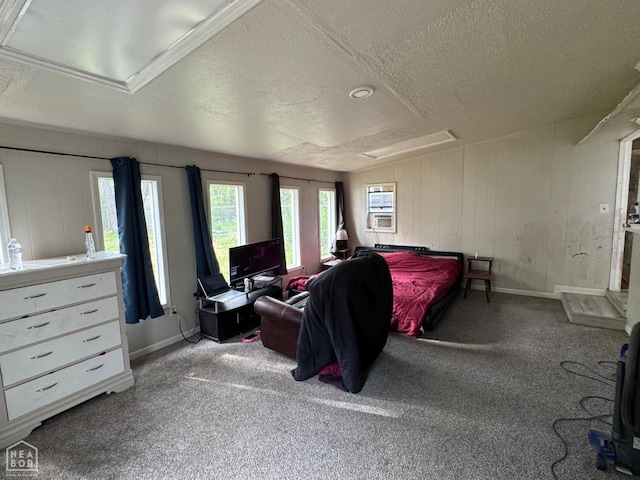 carpeted bedroom with a textured ceiling, baseboards, and wood walls