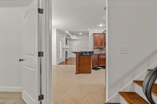 2207 Byrnewood, Jonesboro, AR 72404 - kitchen featuring ornamental molding, brown cabinetry, light tile patterned floors, tasteful backsplash, and baseboards