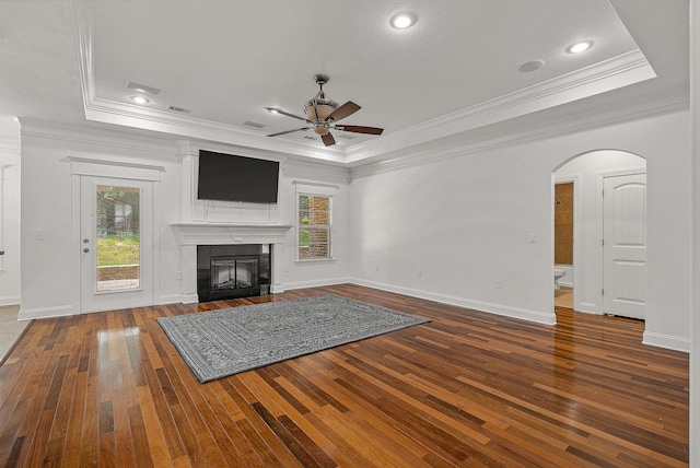2207 Byrnewood, Jonesboro, AR 72404 - unfurnished living room featuring hardwood / wood-style flooring, crown molding, a ceiling fan, a raised ceiling, and arched walkways