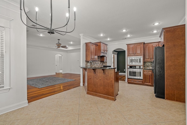 2207 Byrnewood, Jonesboro, AR 72404 - kitchen featuring arched walkways, stainless steel appliances, crown molding, light tile patterned floors, and a ceiling fan