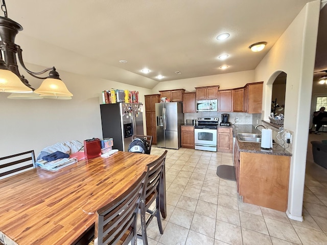 113 Harmony Loop, Maumelle, AR 72113 - kitchen with stainless steel appliances, a sink, light tile patterned flooring, brown cabinetry, and backsplash