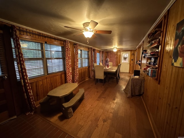821 S 12th Ave, Piggott, AR 72454 - dining area with a ceiling fan, wood finished floors, and wood walls