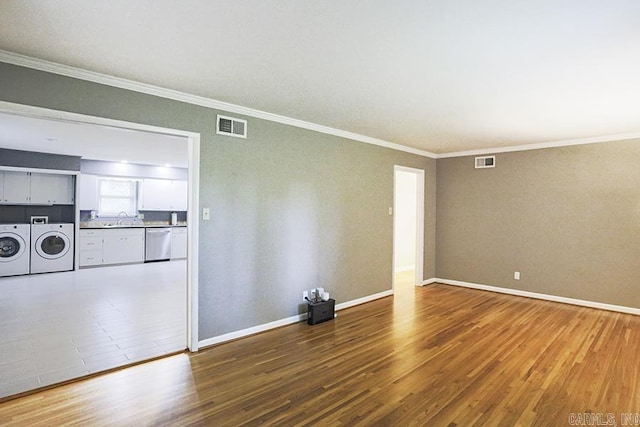 5 Brookridge Dr, Little Rock, AR 72205 - empty room featuring washer and clothes dryer, a sink, crown molding, wood finished floors, and baseboards