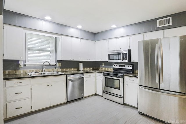 5 Brookridge Dr, Little Rock, AR 72205 - kitchen featuring stainless steel appliances, a sink, dark countertops, white cabinetry, and recessed lighting