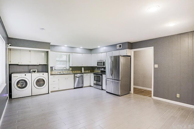 5 Brookridge Dr, Little Rock, AR 72205 - kitchen featuring appliances with stainless steel finishes, separate washer and dryer, a sink, dark countertops, and light wood finished floors