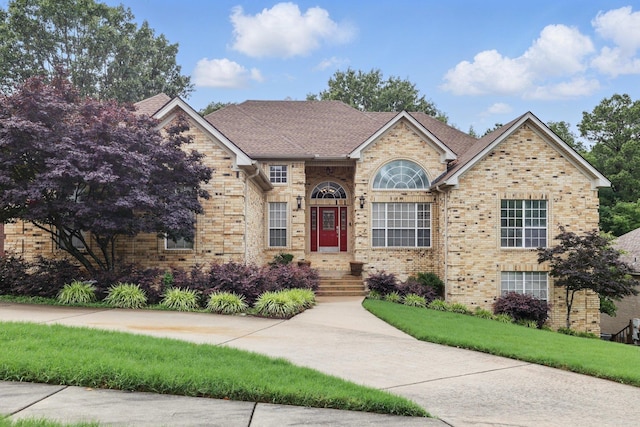 5017 Calico Creek Cv, North Little Rock, AR 72116 - view of front of home featuring brick siding, a front lawn, and a shingled roof