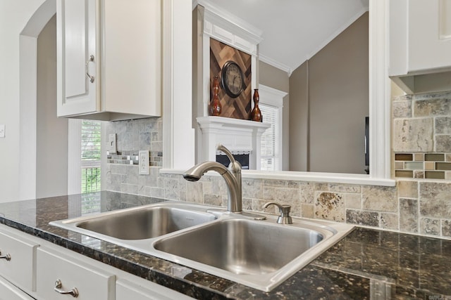 5017 Calico Creek Cv, North Little Rock, AR 72116 - kitchen featuring a sink, ornamental molding, white cabinets, decorative backsplash, and a fireplace