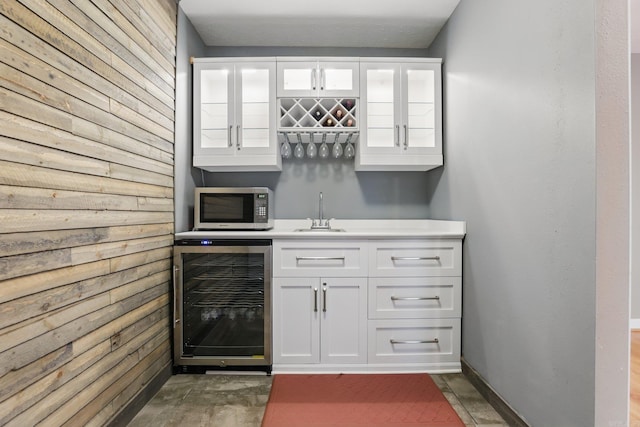 5017 Calico Creek Cv, North Little Rock, AR 72116 - indoor wet bar featuring wine cooler, stainless steel microwave, and wooden walls