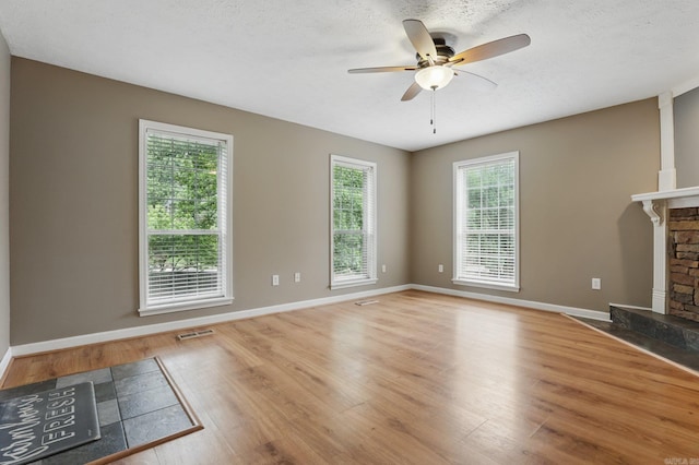 5017 Calico Creek Cv, North Little Rock, AR 72116 - unfurnished living room with a ceiling fan, wood finished floors, a fireplace, and baseboards
