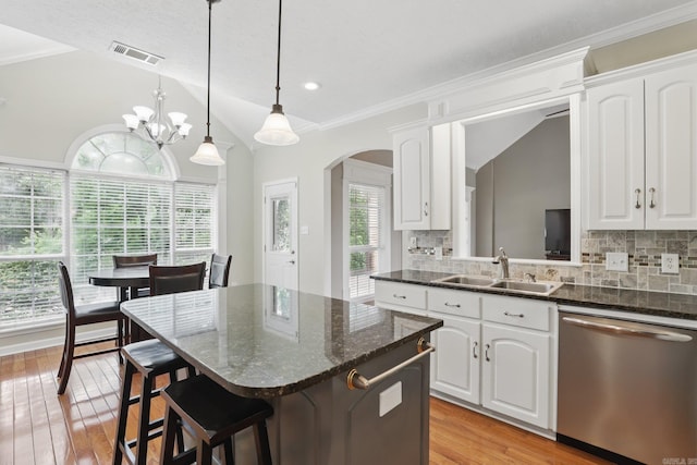 5017 Calico Creek Cv, North Little Rock, AR 72116 - kitchen featuring stainless steel dishwasher, a sink, vaulted ceiling, arched walkways, and a center island