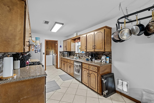 16 Clinton Ct, Cabot, AR 72023 - kitchen featuring dishwasher, decorative backsplash, brown cabinetry, and light tile patterned flooring