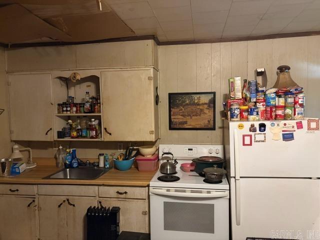 1301A Imboden St, Pocahontas, AR 72455 - kitchen featuring white appliances, a sink, light countertops, and wooden walls