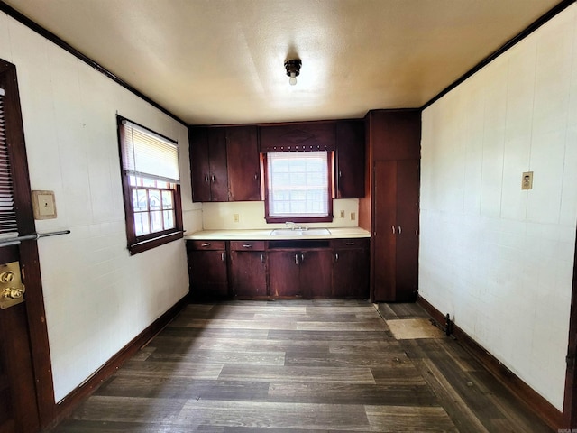 1930 S Olive, Pine Bluff, AR 71603 - kitchen with dark wood-type flooring, light countertops, a sink, reddish brown cabinets, and baseboards