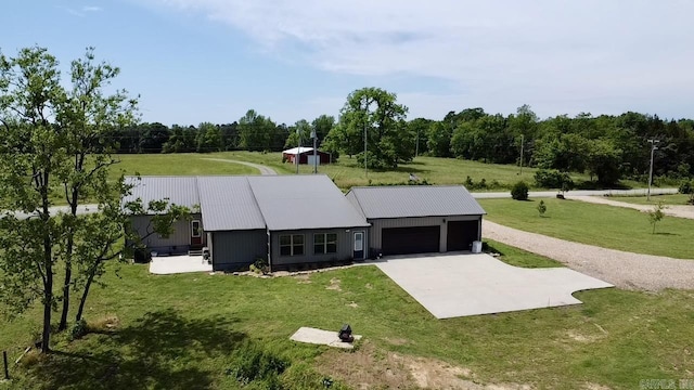 5867 County Road 4160, Ozark, AR 72949 - view of front facade with concrete driveway, a garage, a front lawn, metal roof, and a wooded view