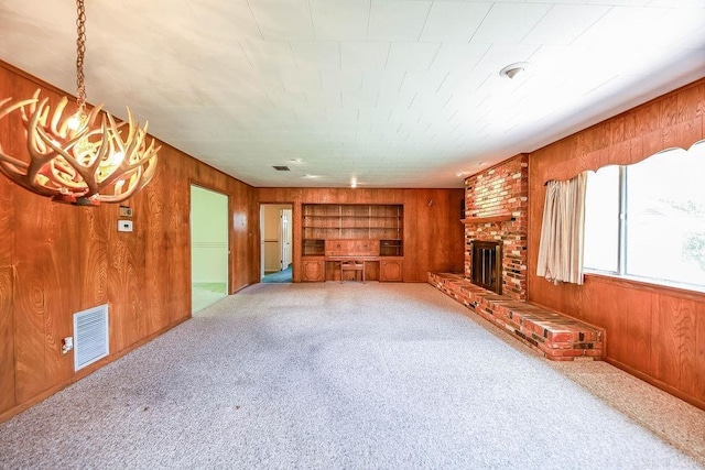 1706 W Block St, El Dorado, AR 71730 - unfurnished living room with wooden walls, carpet flooring, and a fireplace