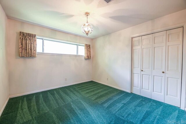 1706 W Block St, El Dorado, AR 71730 - unfurnished bedroom with carpet, a closet, baseboards, and a chandelier