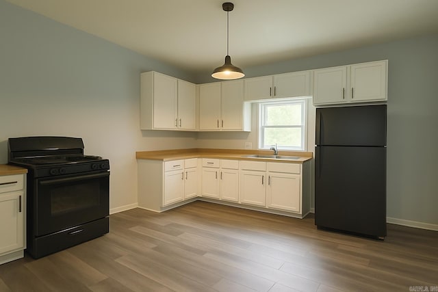 1621 Maple St, North Little Rock, AR 72114 - kitchen featuring black appliances, a sink, wood finished floors, and white cabinetry