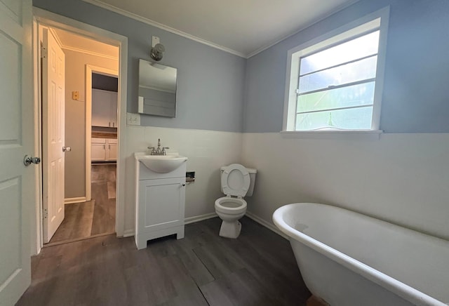 1621 Maple St, North Little Rock, AR 72114 - bathroom with a soaking tub, vanity, crown molding, wood finished floors, and toilet