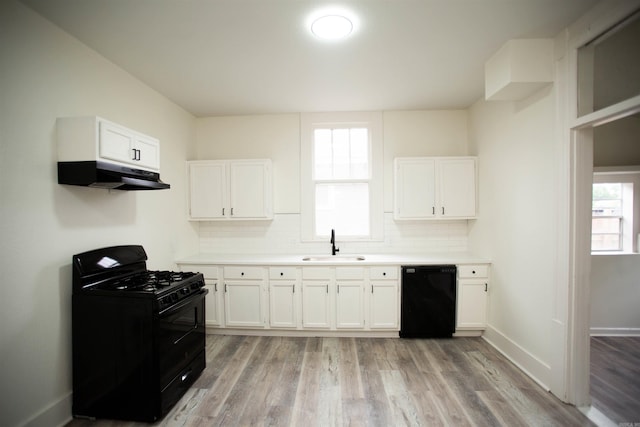 2715 S State St, Little Rock, AR 72206 - kitchen featuring black appliances, under cabinet range hood, a sink, and white cabinetry