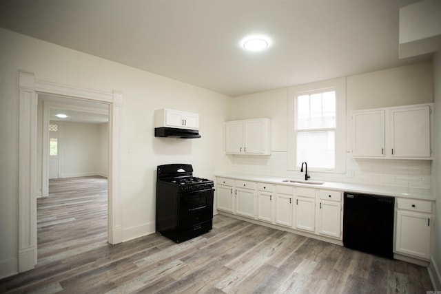 2715 S State St, Little Rock, AR 72206 - kitchen with black appliances, a sink, under cabinet range hood, white cabinets, and light countertops