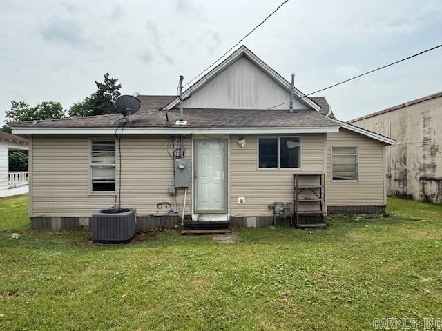 217 SE 3rd, England, AR 72046 - back of property with central AC unit, a yard, entry steps, and a shingled roof