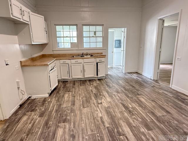 217 SE 3rd, England, AR 72046 - kitchen with a sink, white cabinetry, dark wood-type flooring, and ornamental molding