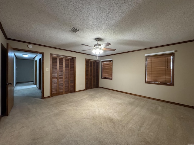 5901 Star Ln, Little Rock, AR 72223 - unfurnished bedroom with ornamental molding, multiple closets, light carpet, a textured ceiling, and ceiling fan