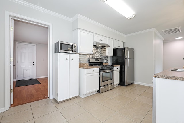 831 Jackman St, Benton, AR 72015 - kitchen featuring stainless steel appliances, under cabinet range hood, light tile patterned flooring, white cabinetry, and backsplash