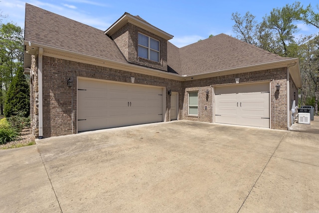 1606 Hilldale, Alexander, AR 72002 - view of front facade with concrete driveway, brick siding, a shingled roof, and cooling unit