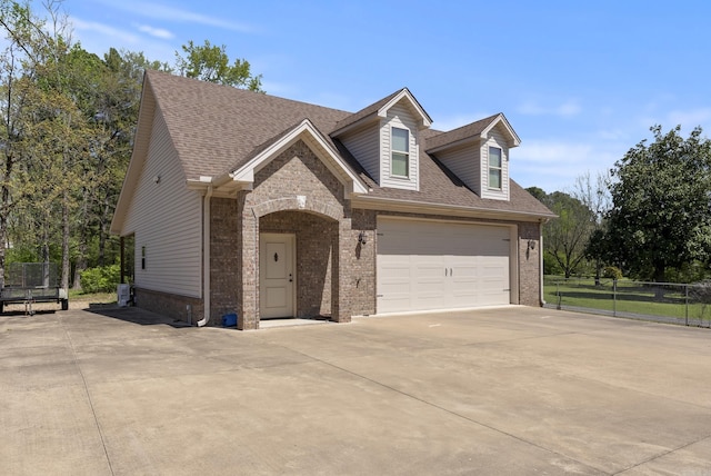 1606 Hilldale, Alexander, AR 72002 - view of front of property with brick siding, concrete driveway, a shingled roof, and a trampoline