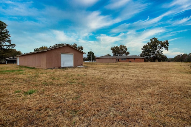 view of grassy yard with an outbuilding and a garage