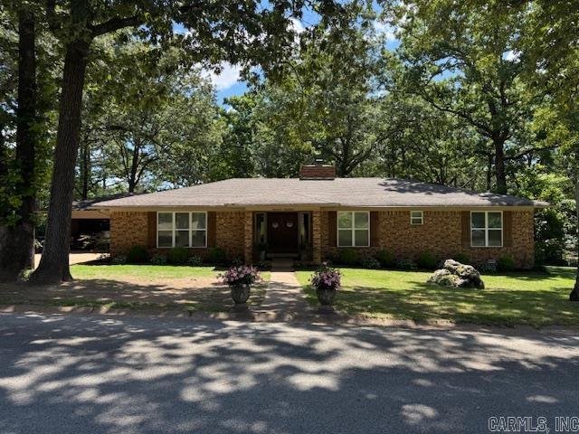 2012 Paula St, Pocahontas, AR 72455 - view of front of house featuring a chimney, a front yard, and brick siding