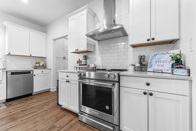 1973 Campground Rd, Cabot, AR 72023 - kitchen featuring stainless steel appliances, wall chimney range hood, light countertops, backsplash, and white cabinets
