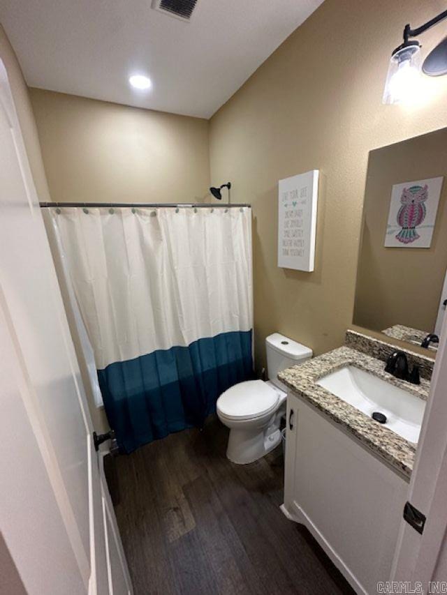 1415 Ben St, North Little Rock, AR 72117 - full bathroom featuring wood finished floors, vanity, toilet, and curtained shower