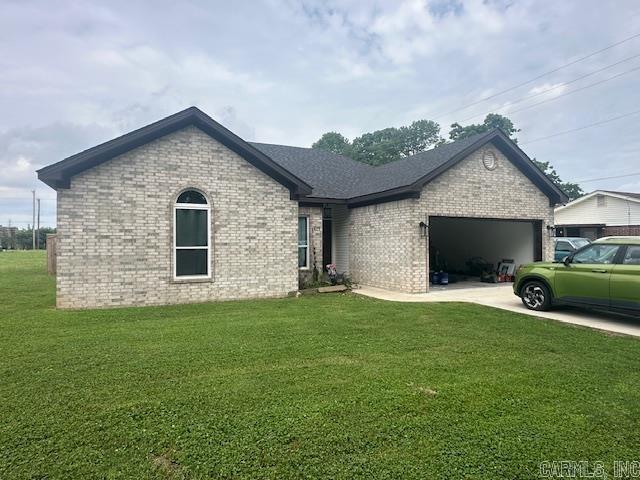 1415 Ben St, North Little Rock, AR 72117 - view of front of house with brick siding, a garage, concrete driveway, and a front lawn