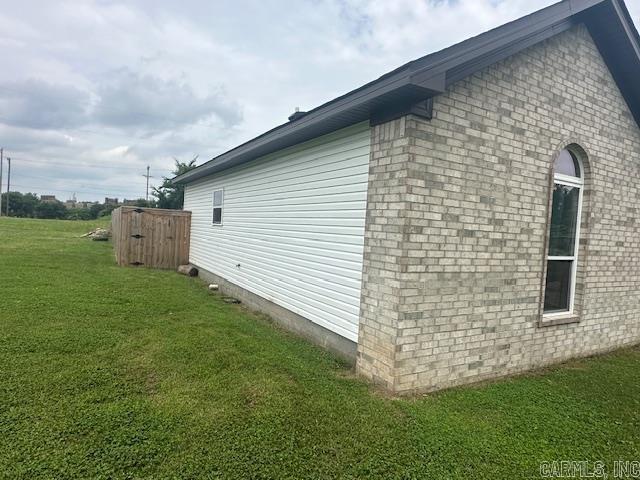 1415 Ben St, North Little Rock, AR 72117 - view of side of property with a lawn and brick siding