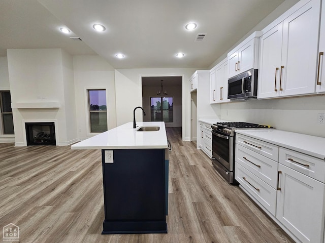 125 Hidden Creek Dr, Brookland, AR 72417 - kitchen with appliances with stainless steel finishes, a sink, light wood-style floors, light countertops, and white cabinets