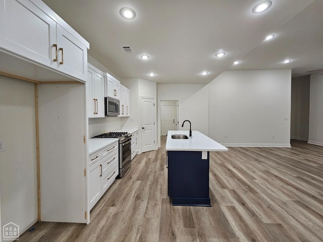 125 Hidden Creek Dr, Brookland, AR 72417 - kitchen with appliances with stainless steel finishes, a sink, light wood finished floors, a center island with sink, and recessed lighting
