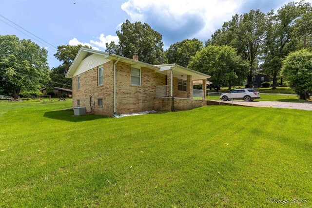 46 Hillcrest Rd, Mammoth Spring, AR 72554 - view of home's exterior featuring a chimney, covered porch, a lawn, brick siding, and central air condition unit