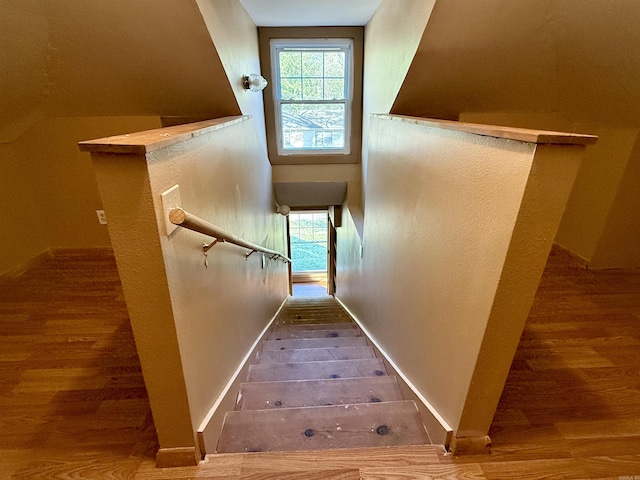 staircase with wood finished floors and baseboards