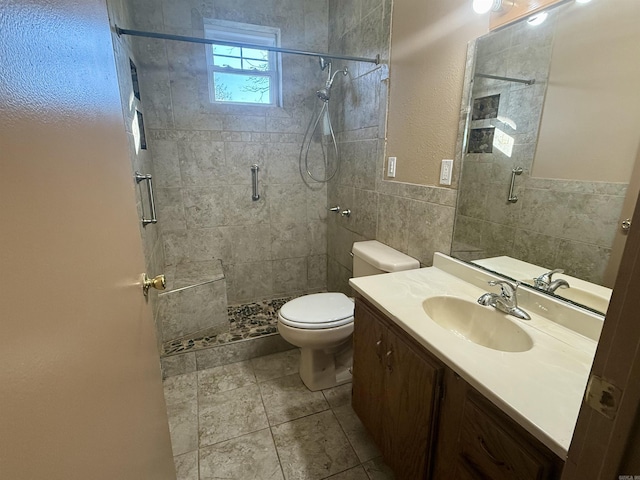 full bath featuring tile walls, toilet, a stall shower, vanity, and tile patterned floors
