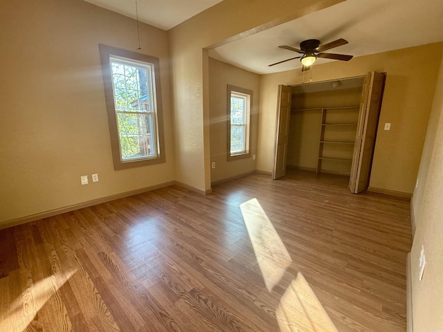 unfurnished bedroom featuring light wood-type flooring, baseboards, and a closet