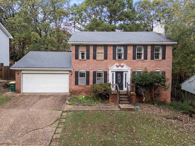 23 Morrison Ct, Little Rock, AR 72212 - colonial house featuring a garage, driveway, brick siding, and a chimney