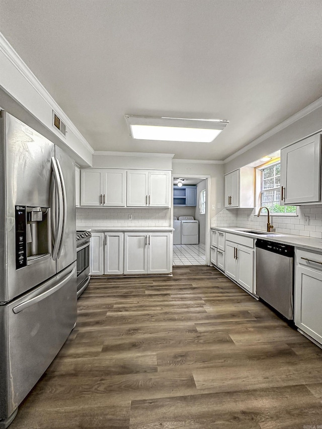 23 Morrison Ct, Little Rock, AR 72212 - kitchen with stainless steel appliances, washer and clothes dryer, a sink, crown molding, and decorative backsplash