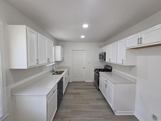4518 W 25th, Little Rock, AR 72204 - kitchen featuring appliances with stainless steel finishes, a sink, white cabinetry, recessed lighting, and wood finished floors